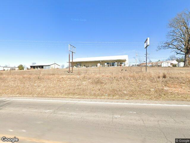 Allen's Affordable Appliance seen from Highway 64, on a rise with a large tree beside it